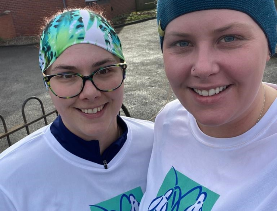 Two supporters wearing hospice tee shirts standing outside